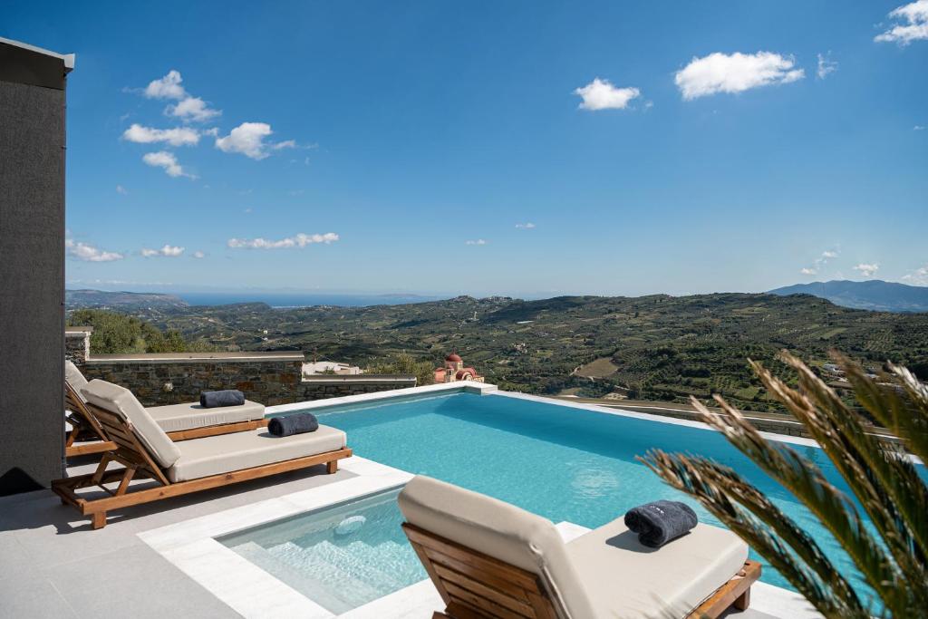 a swimming pool with chaise lounge chairs and a swimming poolvisor at Villa Amavi - Private heated pool in Kato Asites