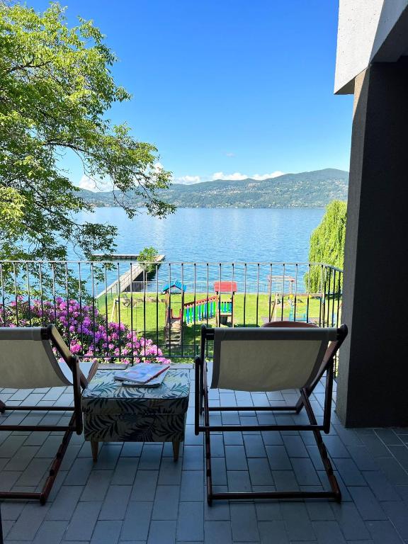 a patio with two chairs and a view of the water at Bnbook Casa Luccio VistaLago Ispra in Ispra