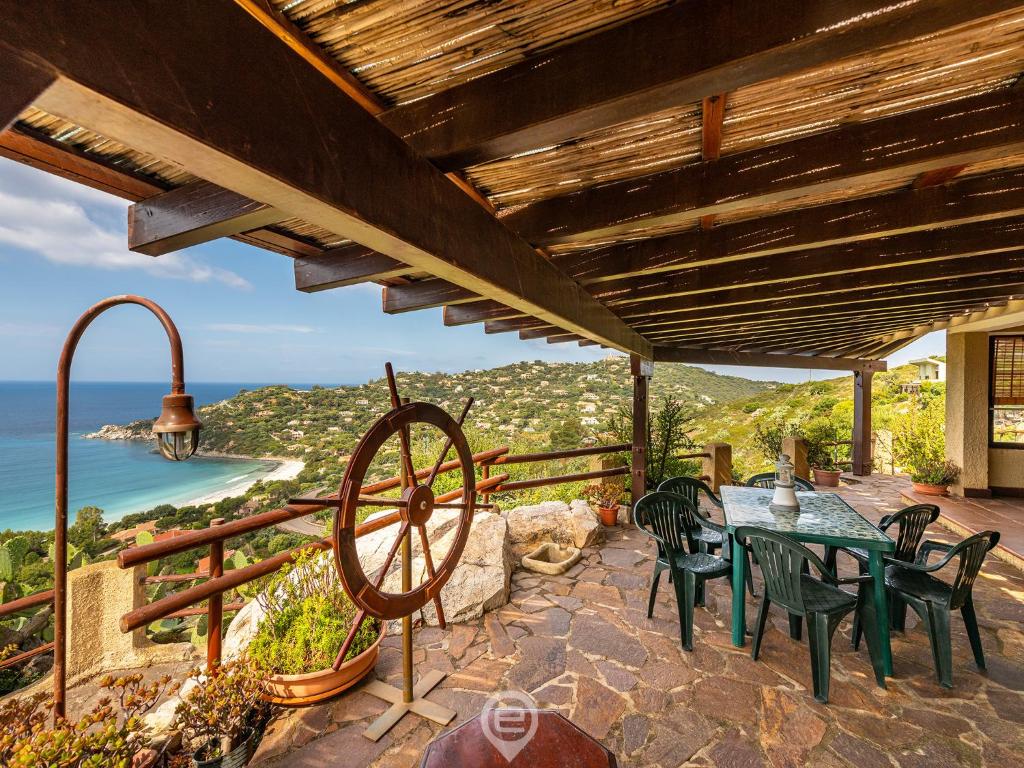 um pátio com uma mesa e cadeiras e vista para o oceano em Enchanting Seaview Getaway em Torre delle Stelle