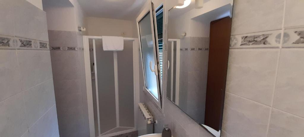 a bathroom with a large mirror and a sink at Hotel Villa Argentina in Riomaggiore