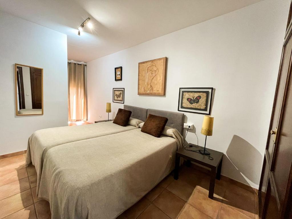 1 dormitorio con 1 cama grande y 1 mesa en Apartamentos Villa Torcal, en Villanueva de la Concepción