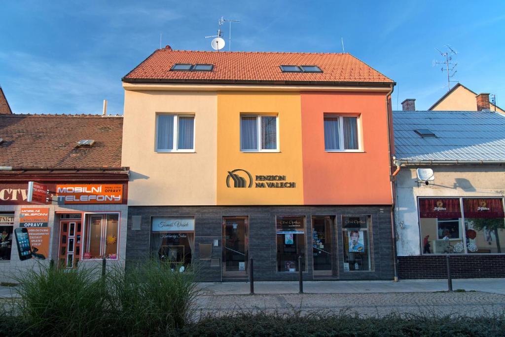 a yellow and orange building on the side of a street at Penzion Na Valech Hodonín in Hodonín