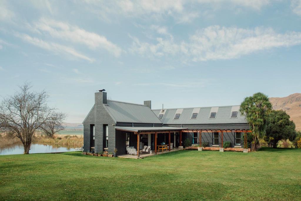 a large house on a field with a lake at Rockwood Karkloof Farm House and Farm Cottage in Howick