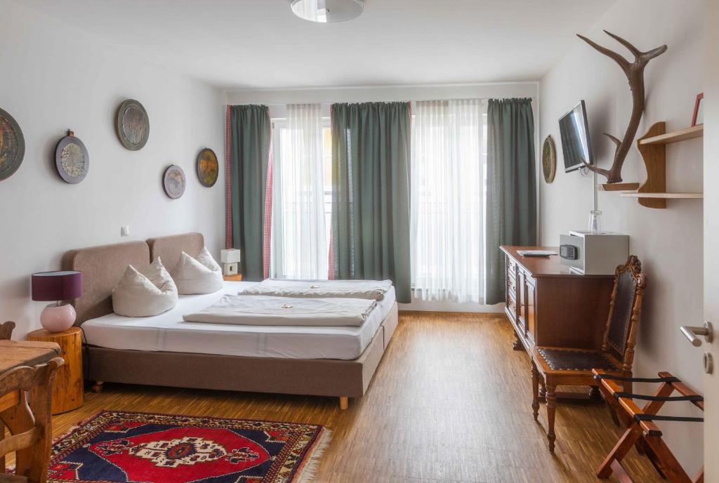 1 dormitorio con 1 cama, 1 mesa y 1 silla en Hotel Freischütz en Landshut