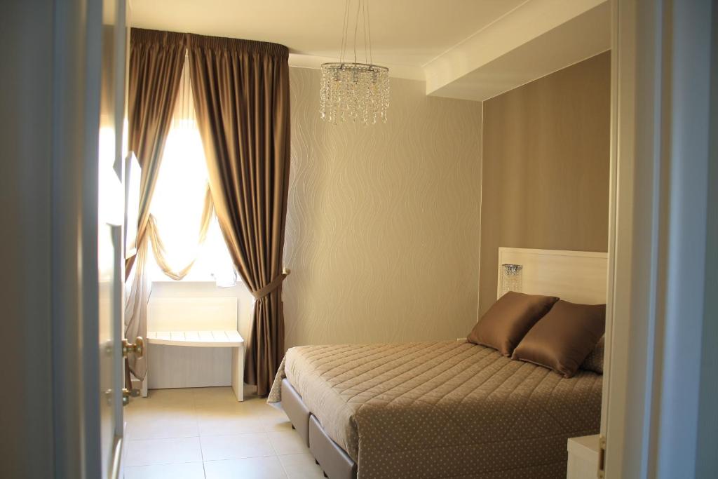 普利亞區格拉維納的住宿－B&B Colle del Re，一间卧室设有一张床、一个窗户和一个吊灯。
