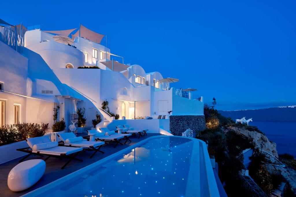 a villa with a swimming pool at night at Canaves Sunday in Oia
