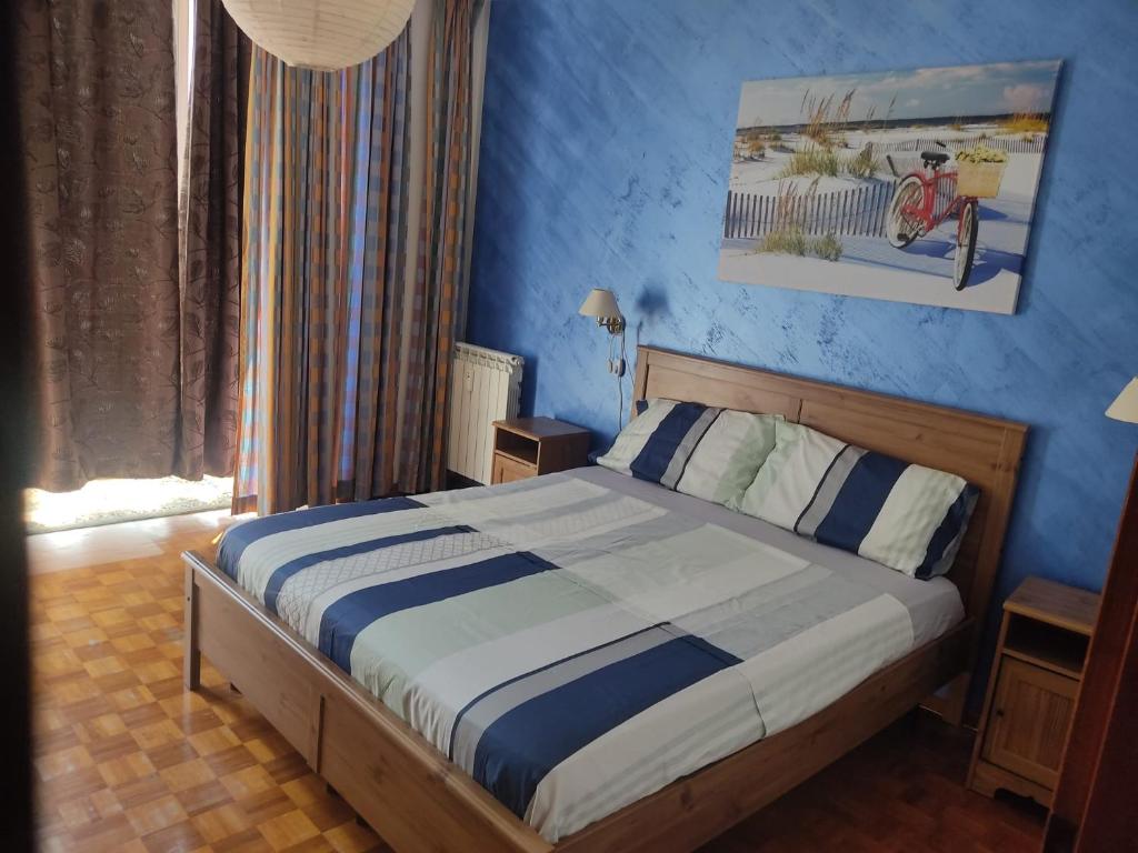 een slaapkamer met een bed met een blauwe muur bij Magica Venezia in Mestre