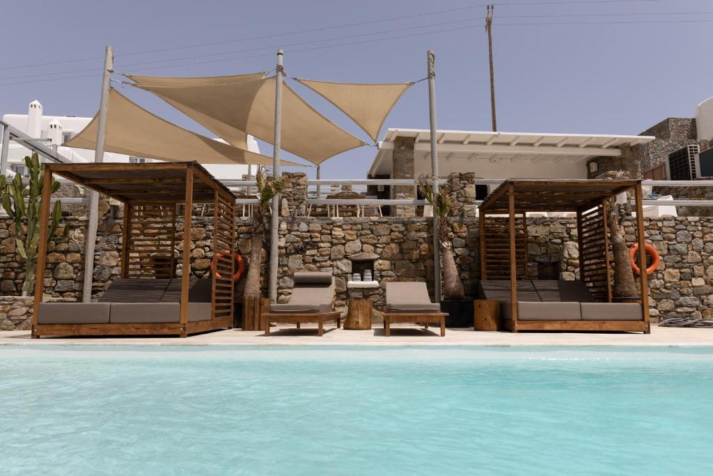 un resort con piscina, sedie e un edificio di Senses Luxury Suites & Villas a Elia Beach