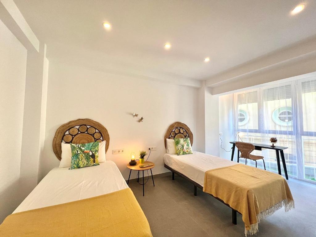 - une chambre avec 2 lits et un bureau dans l'établissement Malagueta beach II & Private Terrace by ELE Apartments, à Malaga