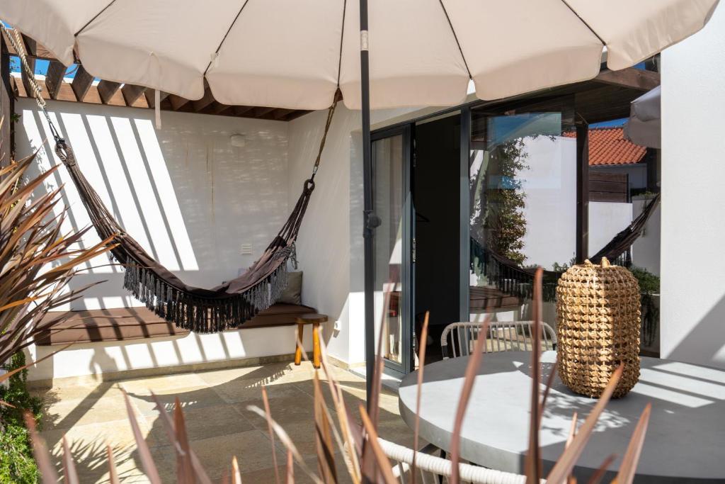 a patio with hammocks and a table and chairs at Casa da Aguda in Colares