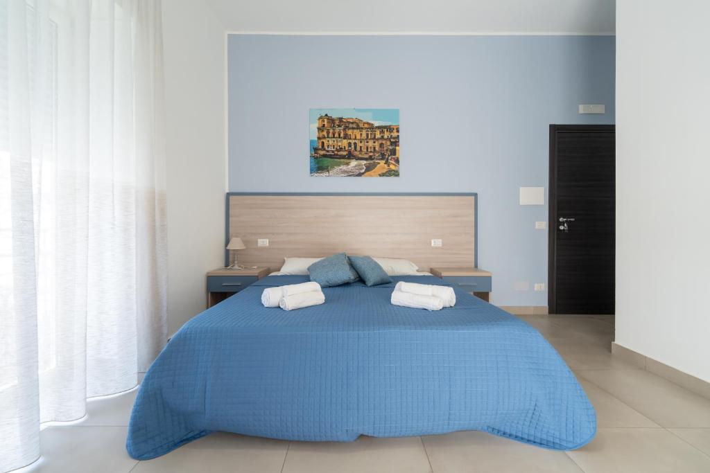 a bedroom with a blue bed with two towels on it at L'Orto del Conte in Naples