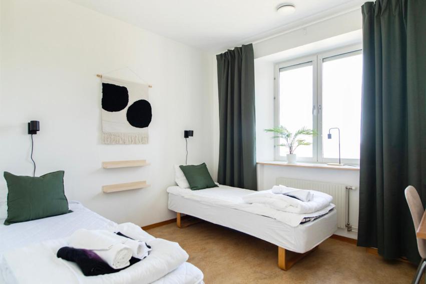 - une chambre avec 2 lits et une fenêtre dans l'établissement Härnösands folkhögskolas Bed & Breakfast, à Härnösand