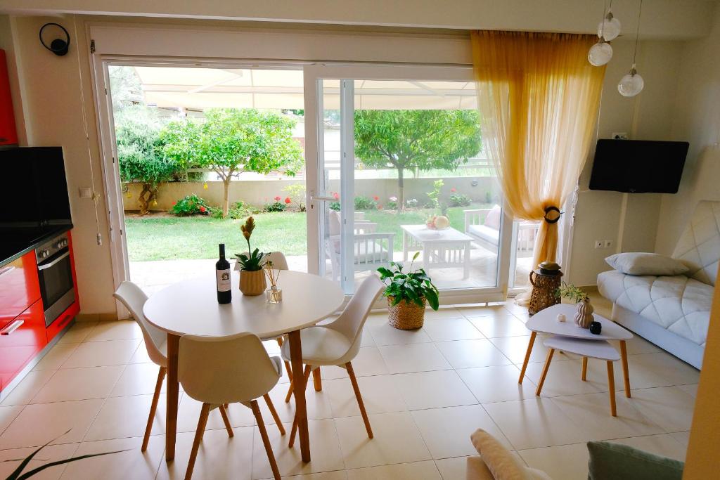 kuchnia i salon ze stołem i krzesłami w obiekcie Oasis Garden House w mieście Iraklitsa