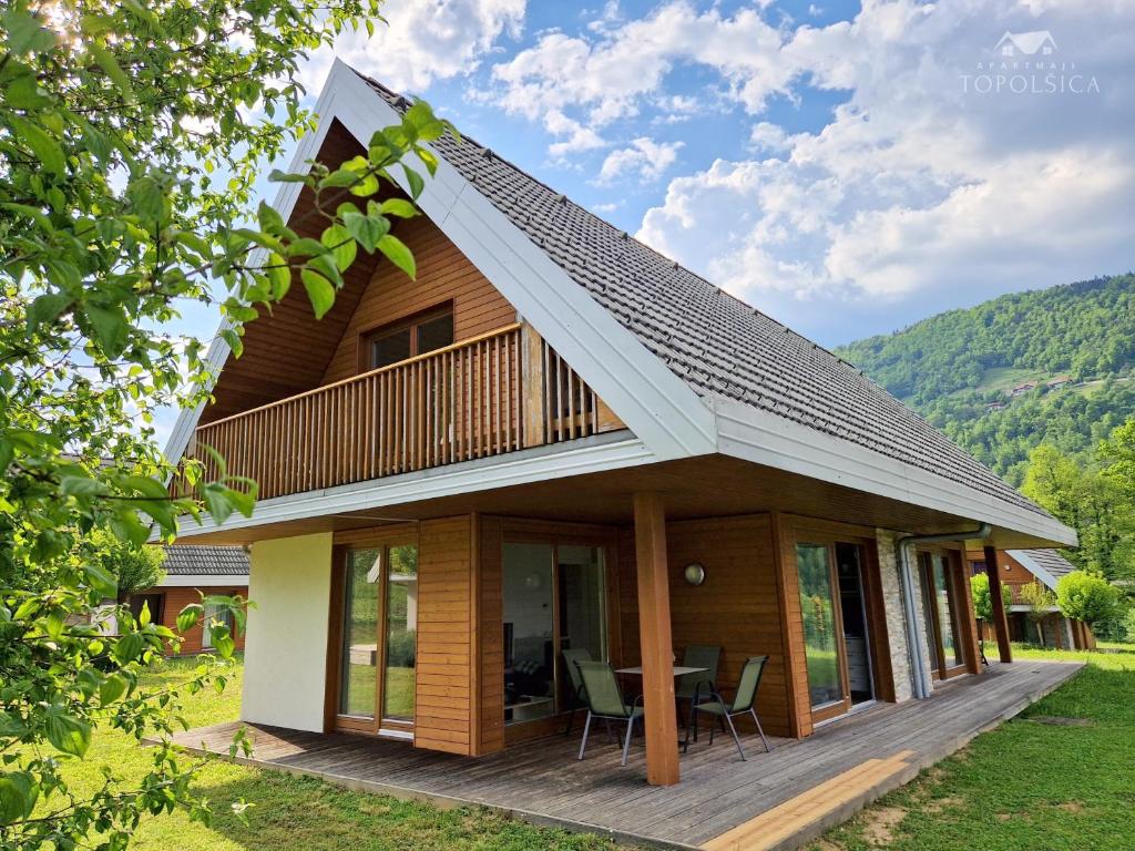 una casa de madera con techo de gambrel en Apartment DREN near terme Topolšica, en Topolšica