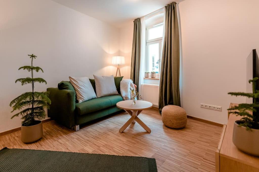 ein Wohnzimmer mit einem grünen Sofa und einem Tisch in der Unterkunft Ferienapartment Regensburg in Regensburg