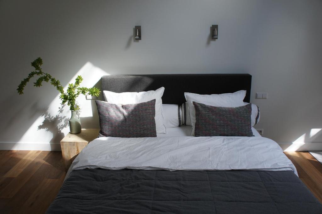 a bedroom with a large bed with pillows at B&B en Boshuis Darthuizerpoort in Leersum