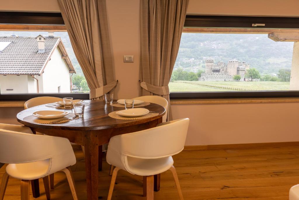 a dining room with a table and chairs and a large window at La Rose du Prevot in Fenis