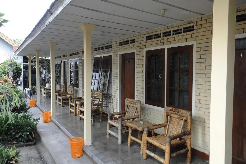 eine Veranda mit Stühlen und Tischen auf einem Haus in der Unterkunft Rapatmaja Mataram Homestay in Tjakranegara