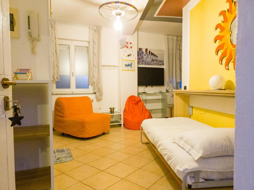 a bedroom with a bed and an orange chair at BIKE HOUSE 4 "beach" in Seriate