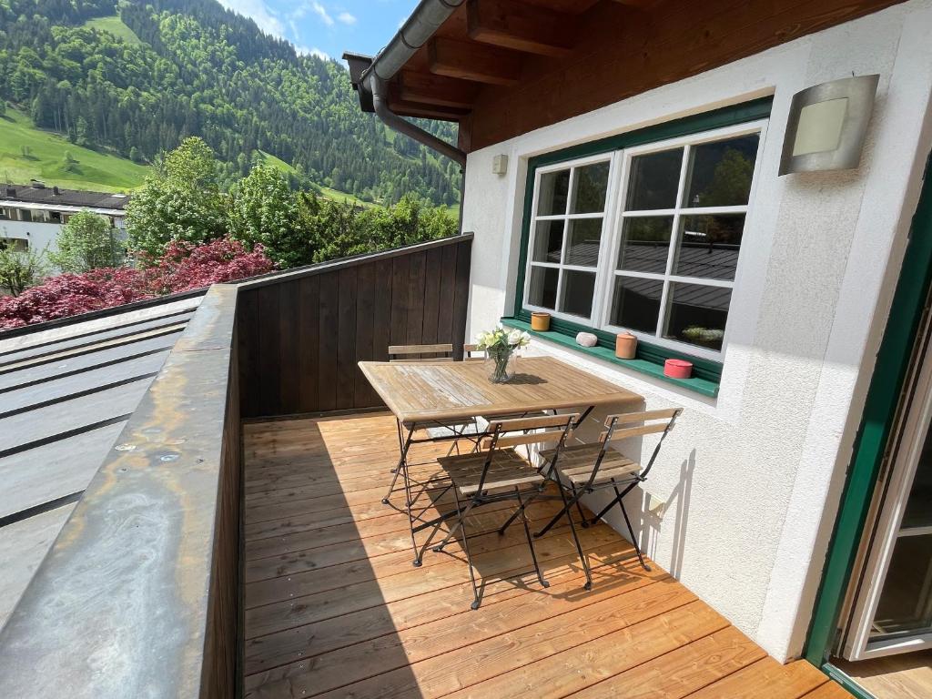 a wooden deck with a table and chairs on a house at Bacherwiese Penthouse by Alpine Host Helpers in Kitzbühel
