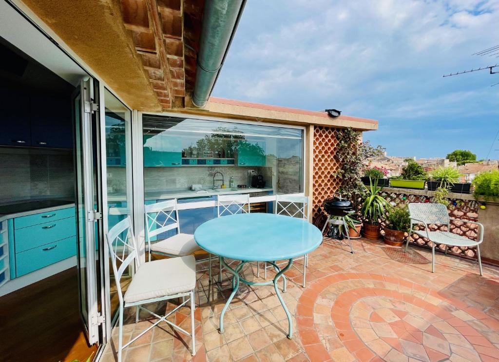 d'une terrasse avec une table et des chaises bleues. dans l'établissement L'Atypique - T3 grande terrasse, BBQ vue et cheminée, à Avignon