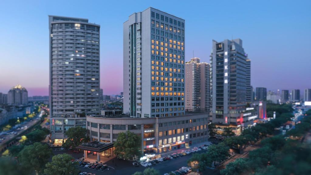 un groupe de grands bâtiments dans une ville la nuit dans l'établissement Kingdom Hotel, à Yiwu