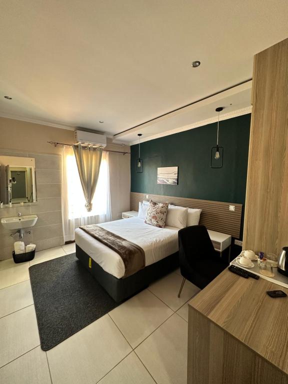 a hotel room with a bed and a sink at LIVE-INN LUXURY SUITES in Mahalapye