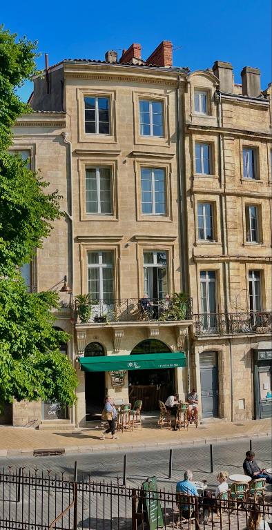 Un bâtiment avec des personnes assises à table devant lui dans l'établissement LOLA Boutique Hôtel - Bordeaux Centre, à Bordeaux