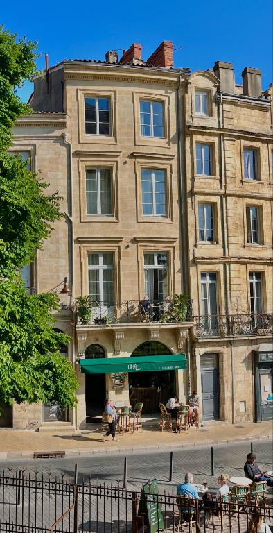 a building with people sitting at tables in front of it at LOLA Boutique Hôtel - Bordeaux Centre in Bordeaux