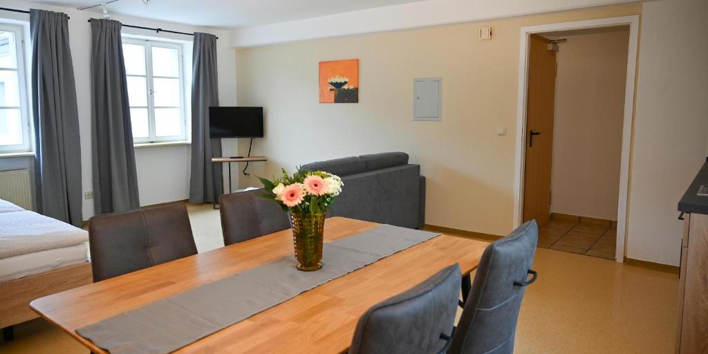 a living room with a table with a vase of flowers on it at Ferienappartements inTOuR in Ockfen