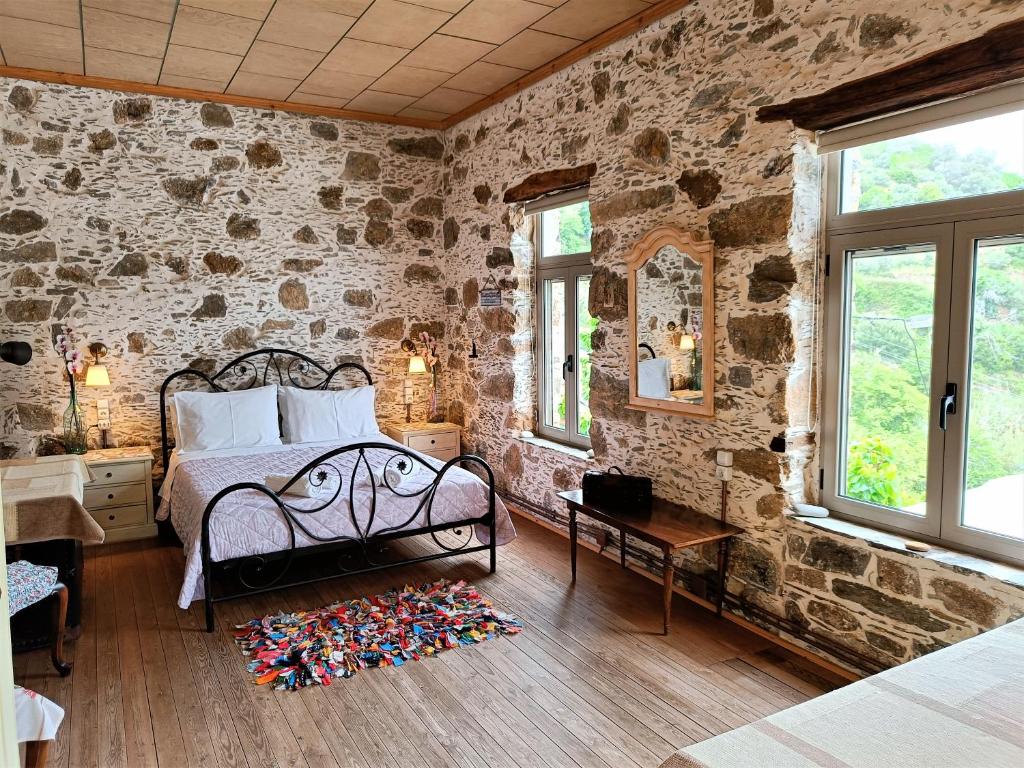 a bedroom with a bed and a stone wall at Casa Pappadiana Traditional stonehouse in Kefálion