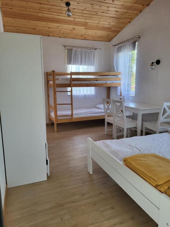 Habitación con cama, mesa y litera. en Atlantic aqua resort en Chłopy
