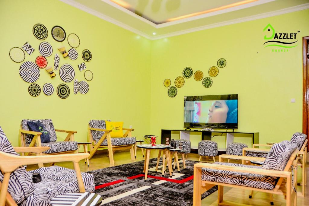 een woonkamer met stoelen en een tv aan de muur bij DAZZLET RWANDA in Kigali
