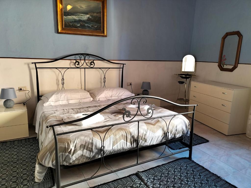 een slaapkamer met een bed met een metalen frame bij Casa vacanze Antonella in Oristano