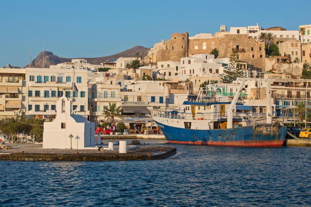 two boats are docked in a harbor with buildings at Naxian Air in Agios Georgios