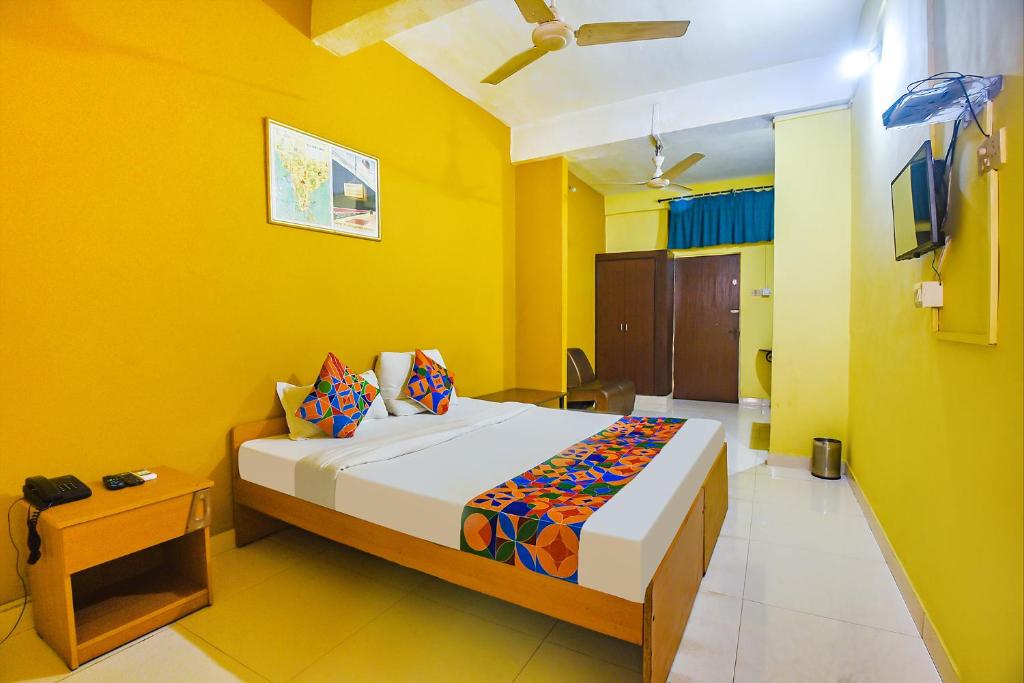 a bedroom with a bed in a yellow room at FabExpress Casa Paradiso, Panaji in Goa