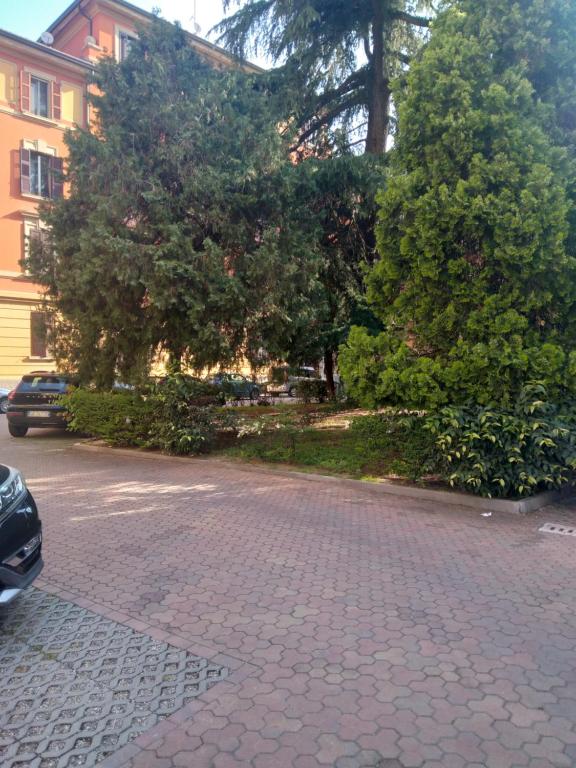 a cobblestone street with trees and a building at APPARTAMENTO CENTRO-LAME in Bologna