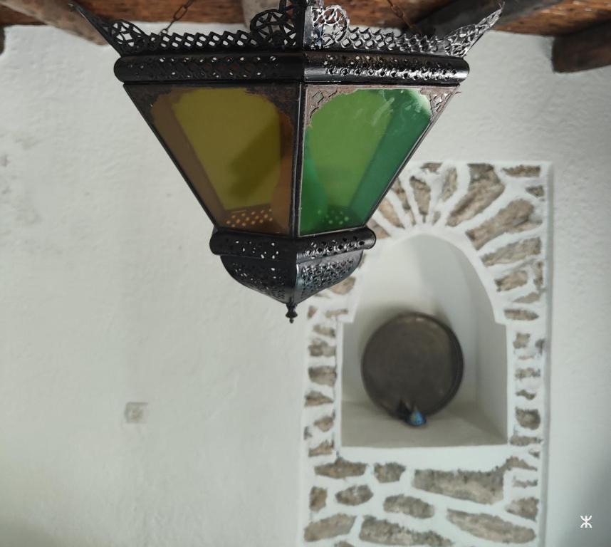 a lamp hanging from a wall with a hole in it at Riad Eucalyptus by Caravanserail in Essaouira