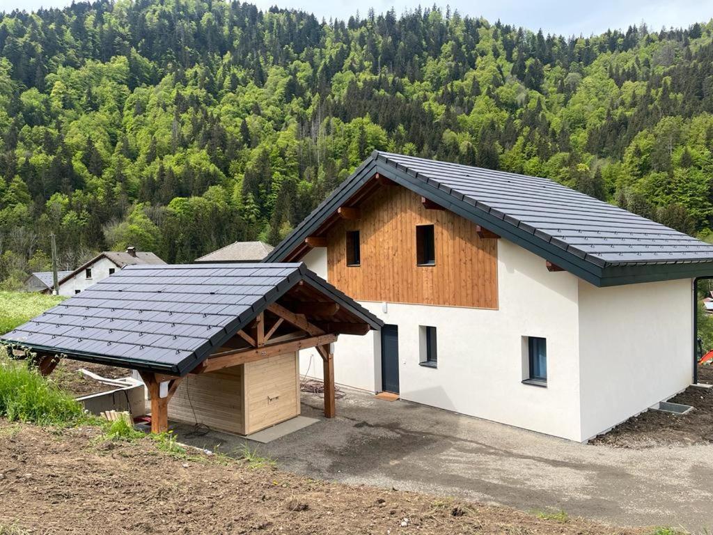 a house with a solar roof on top of it at Luxurious new villa in the Alpes with sauna and jacuzzi in Bellevaux