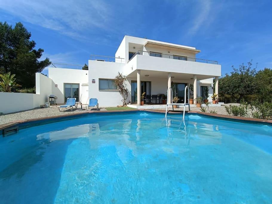 Villa con piscina grande frente a una casa en Modern Villa in Cala Jondal Porroig, en Sant Josep de sa Talaia