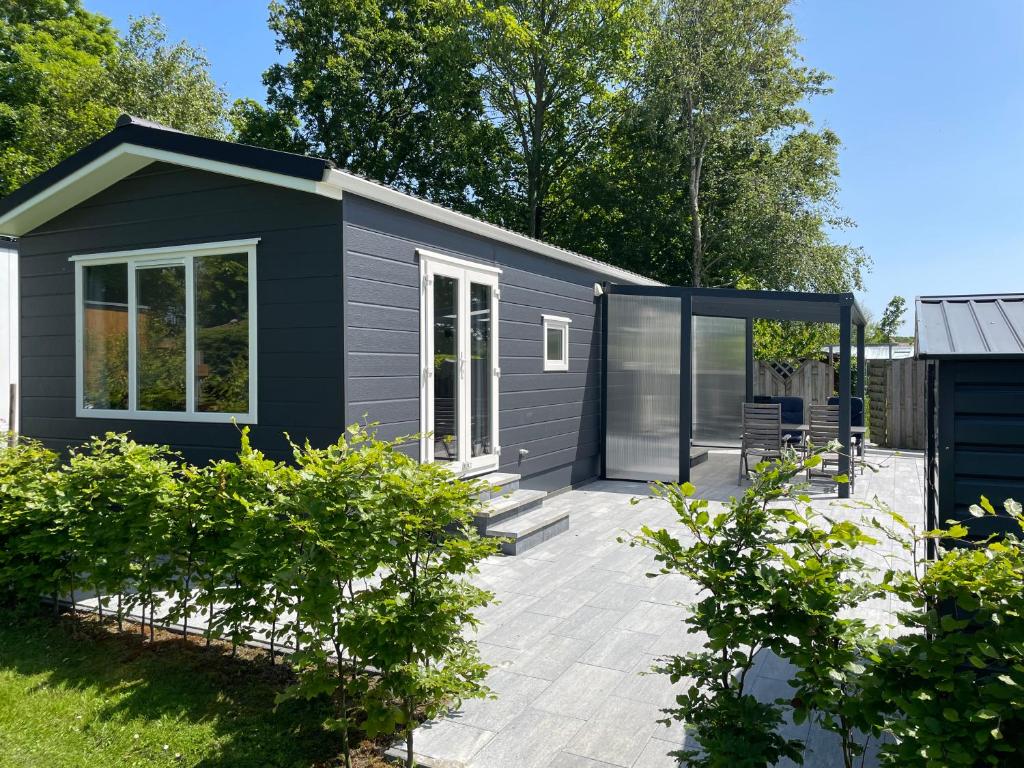 a black tiny house with a patio at Doelweg 35 Chalet 172 in Goedereede