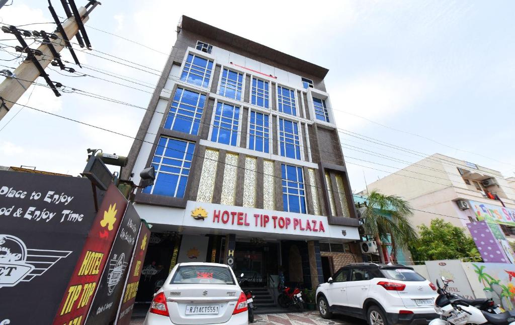 a building with cars parked in front of it at Collection O Tip Top in Jaipur