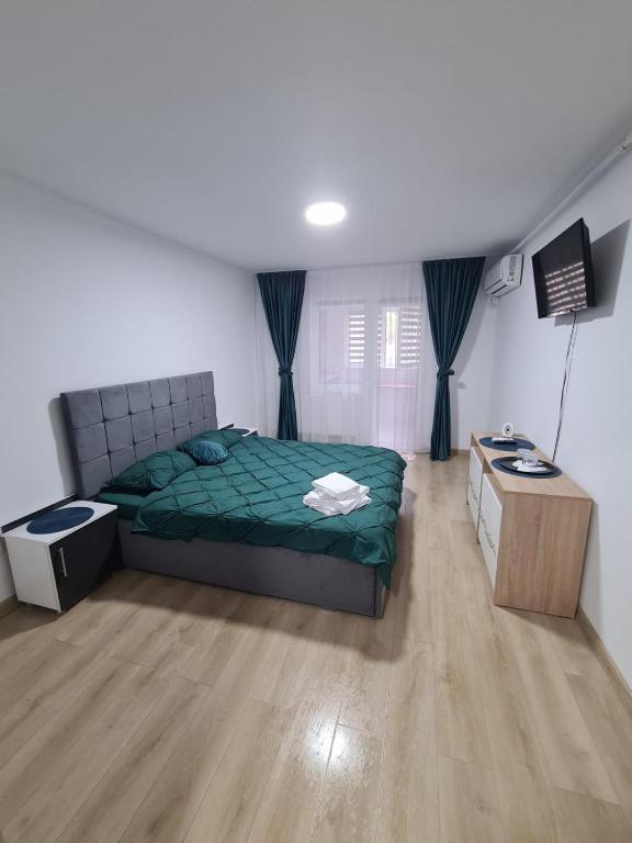 1 dormitorio con cama verde y suelo de madera en Garsoniera Luxury Lorena, en Piteşti