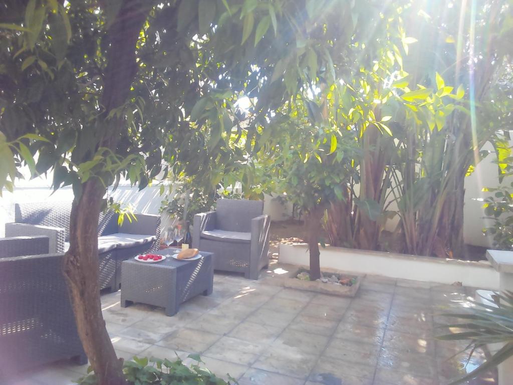 a patio with two chairs and a tree at CASA VACANZA YDROUS in Otranto