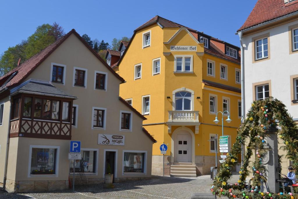 ein gelbes Gebäude neben zwei weißen Gebäuden in der Unterkunft Hotel Wehlener Hof in Stadt Wehlen