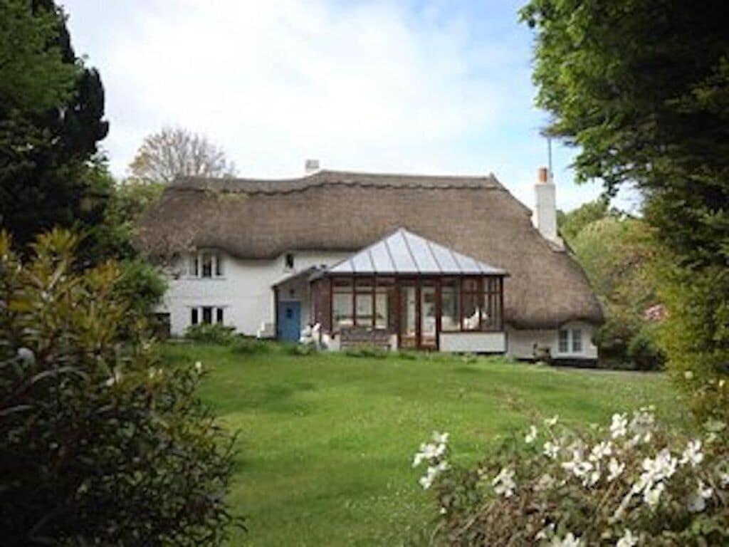 a large white house with a thatched roof at Milton Cottage, Nr Thurlestone - a delightful thatched cottage close to the beach in Thurlestone