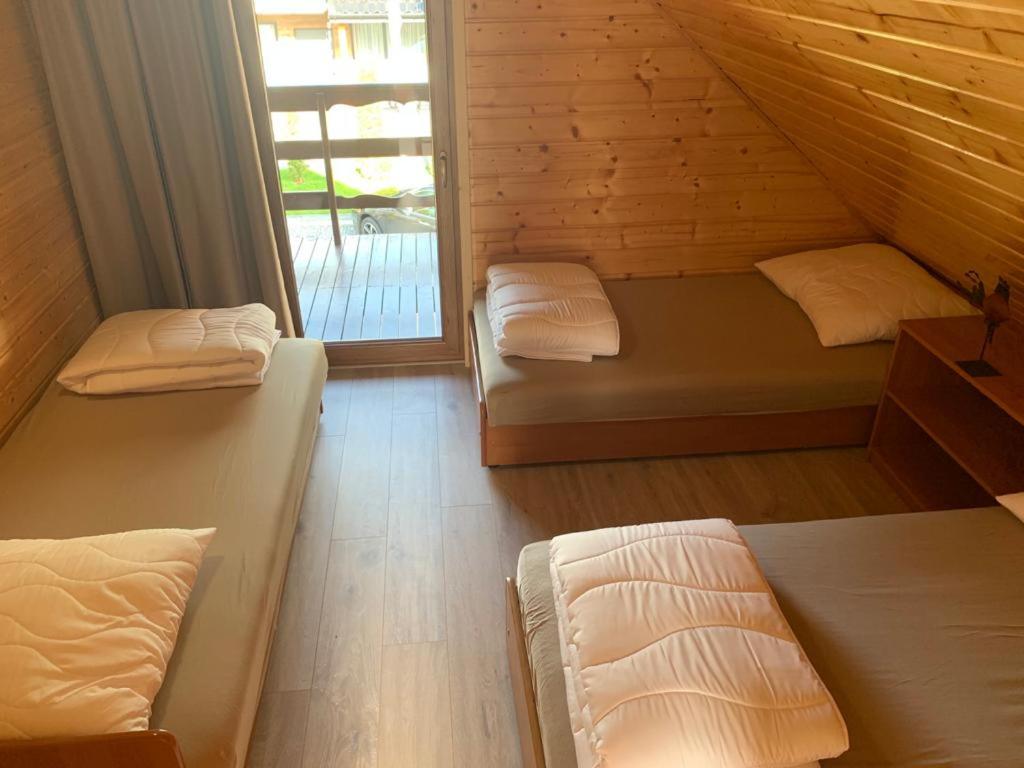 pokój z dwoma łóżkami piętrowymi i oknem w obiekcie Domki letniskowe Ibiza w Dźwirzynie