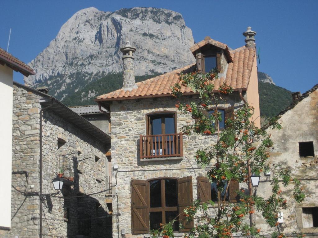 un bâtiment en pierre avec une montagne en arrière-plan dans l'établissement Casa Rural " El Retiro", à Laspuña