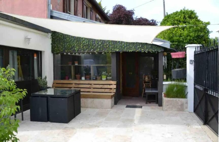 un patio con toldo blanco en un edificio en Leleka Hostel 4 km Disneyland 30 min Paris, en Esbly