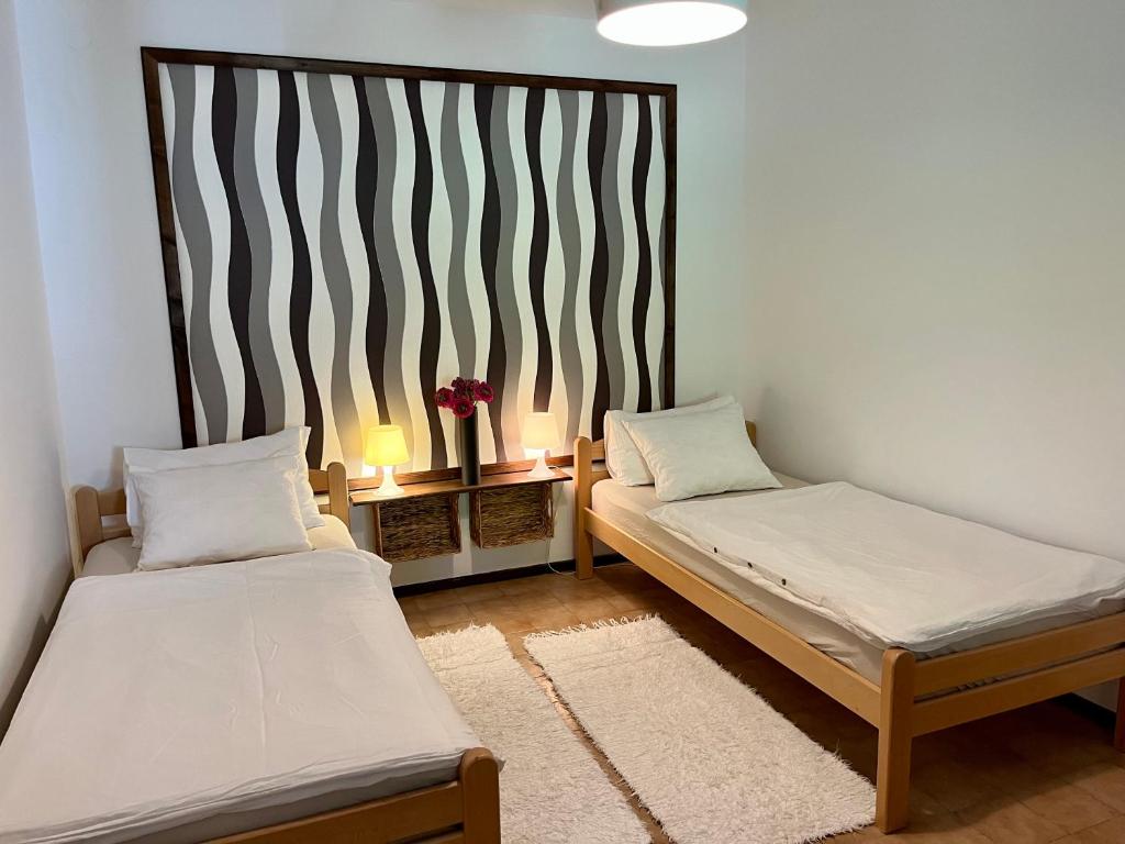 a room with two beds and a table with two lamps at Apartmani Zora in Cres